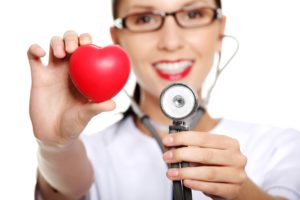 Female doctor holding red heart in hand. Isolated on white background